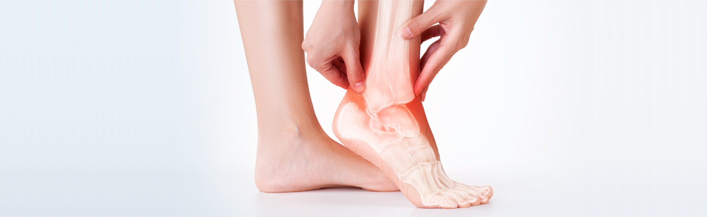 Close-up of a foot with a highlighted ankle joint in red and visible internal bone illustration, while hands hold the ankle, representing ankle pain, injury, inflammation, and joint or tendon strain.