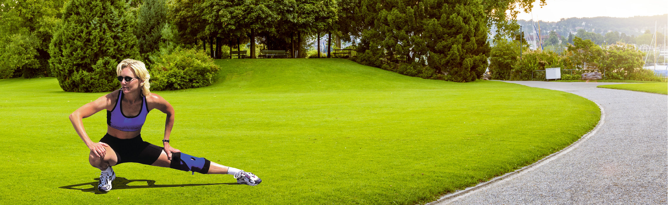 Person performing a wide side lunge in a park while wearing a knee brace, representing knee support and injury prevention exercise.