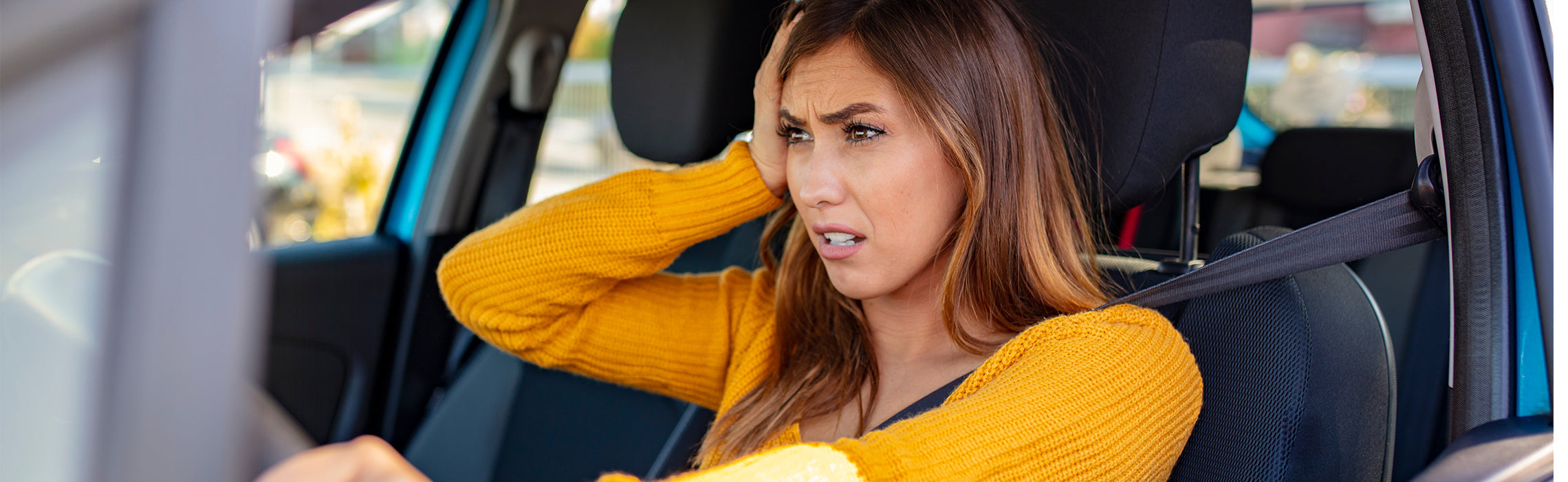 Woman sitting in a car holding her neck in discomfort, illustrating neck pain, muscle strain, and poor driving posture.