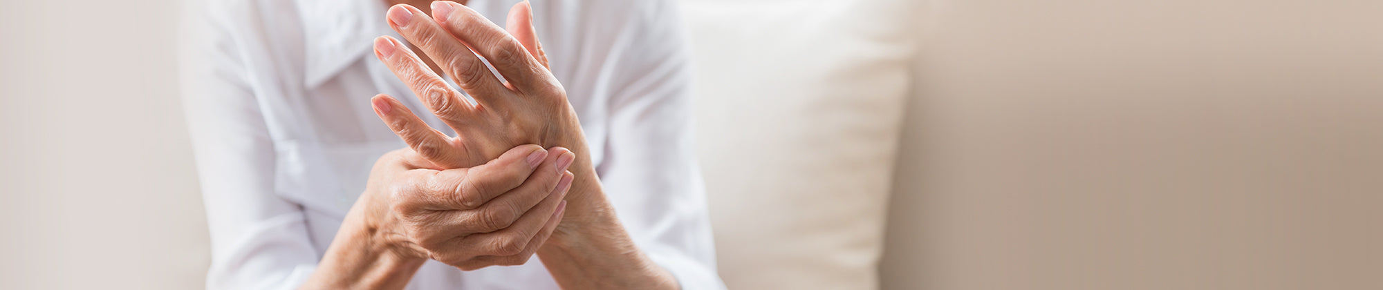 Core Products arthritis pain relief lifestyle banner featuring a person gently holding their wrist; no visible text, highlighting joint discomfort, support needs, and soothing relief solutions.