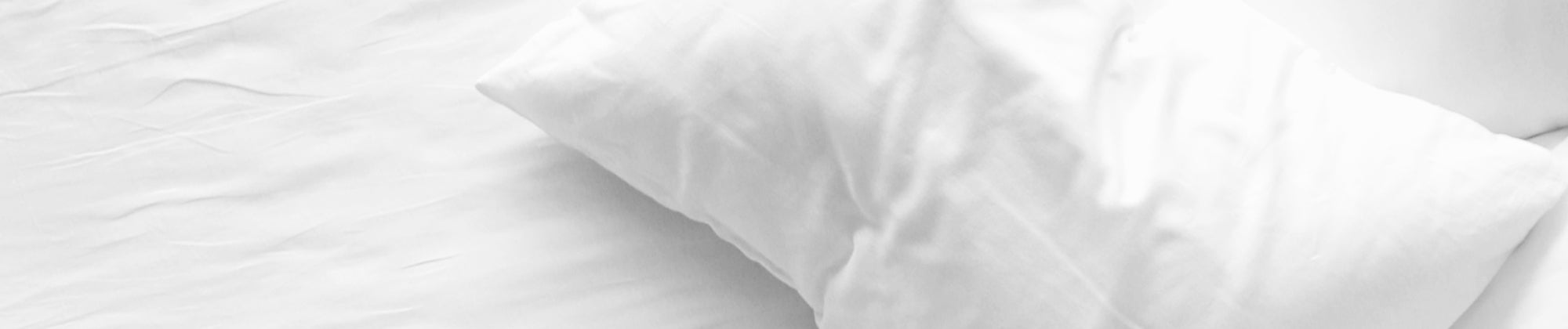 standard bed pillow shown on white bedding; no visible text, highlighting soft support, comfort, and restful sleep.