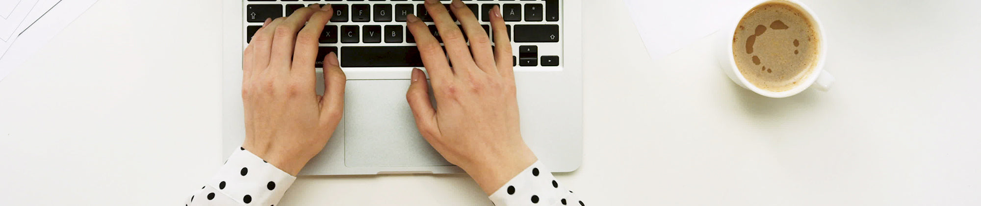 Lifestyle banner featuring hands typing on a laptop beside a cup of coffee; no visible text, highlighting productivity, comfort, and everyday wellness.