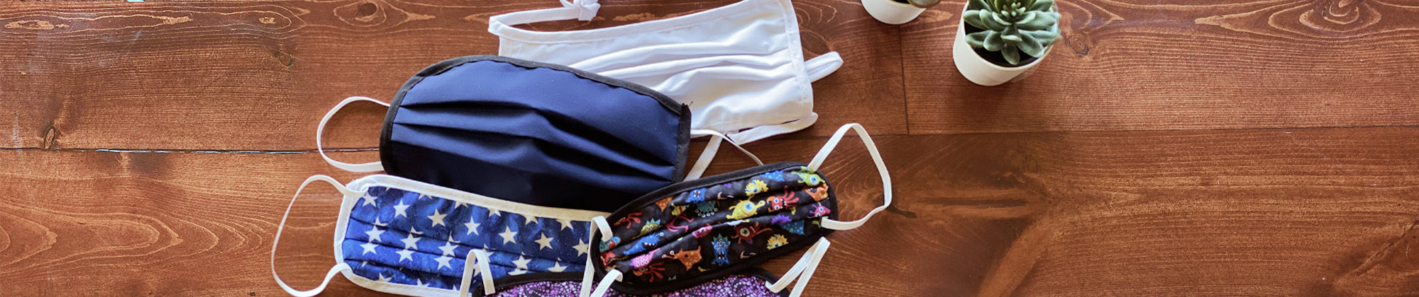 Core Products reusable face masks displayed on a wooden surface in assorted colors and patterns; no visible text, highlighting comfortable, everyday protection and wellness essentials.