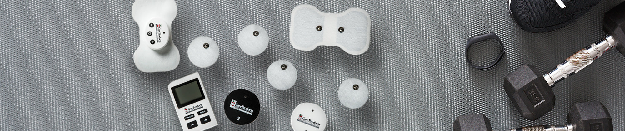 Core Products TENS unit kit displayed with electrode pads, lead wires, and control device on a textured surface; no visible text, highlighting electrical muscle stimulation for pain relief and therapy.