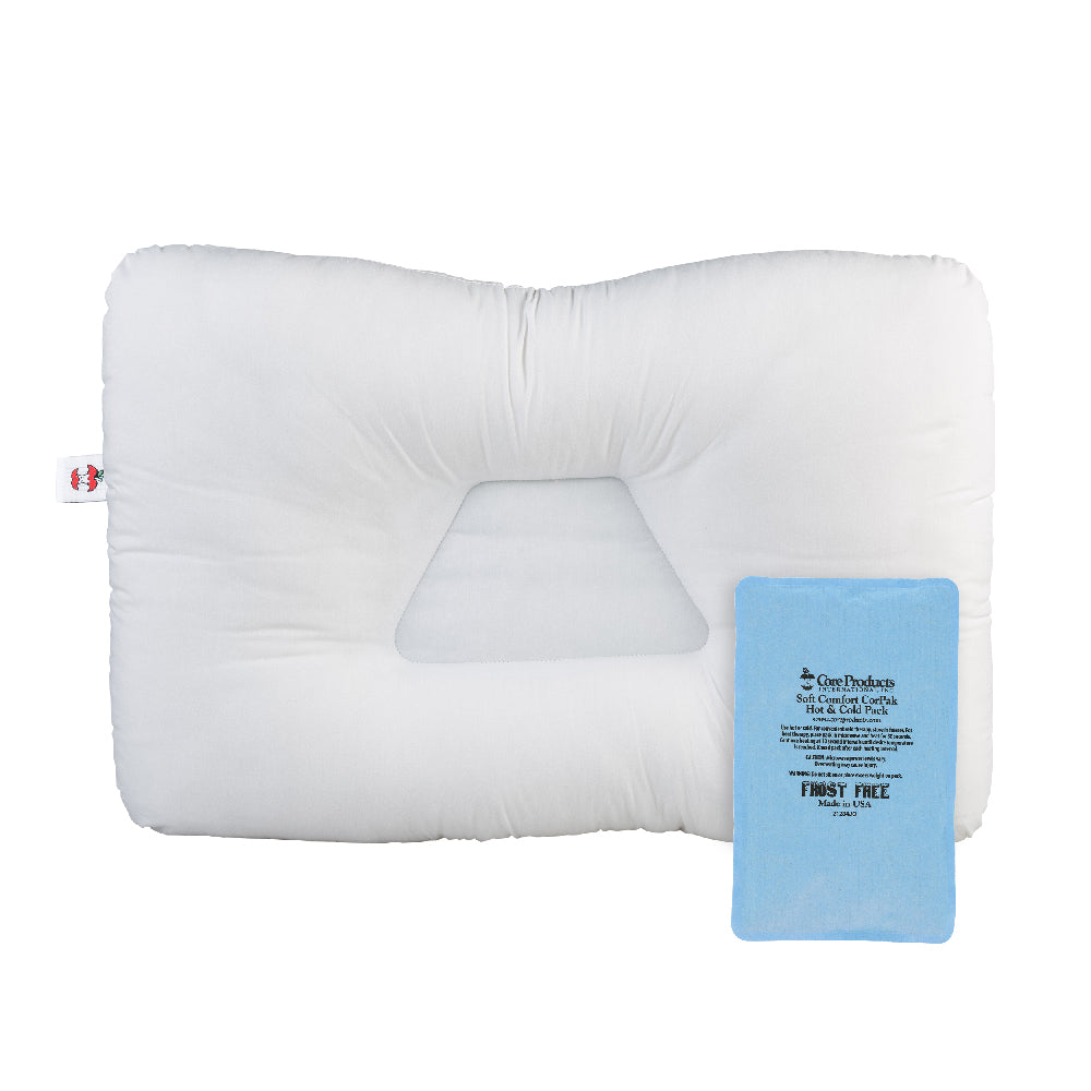 White contoured orthopedic pillow with a recessed center for neck support, shown with a blue Soft Comfort CorPak hot/cold pack placed on top. The pack displays text including “Soft Comfort CorPak,” “Hot or Cold Pack,” usage instructions, “Frost Free,” “Made in USA,” and “#12300.” A small Core Products red apple logo tag is visible on the pillow.
