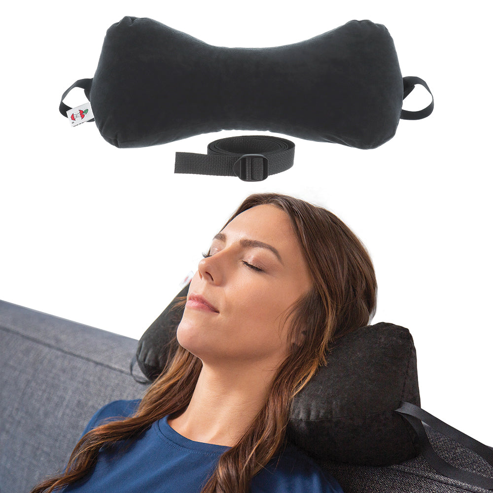 Core Products Sleep Log support pillow in black with adjustable strap, shown alone and in use by a woman resting on a couch. Contoured design supports the neck and head for improved alignment, comfort, and relaxation during rest or travel.