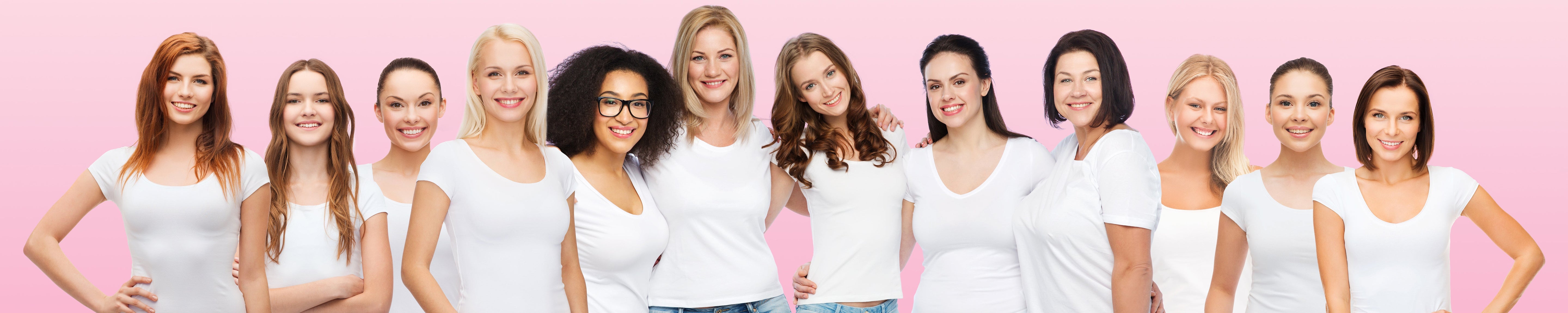 Row of diverse people standing shoulder to shoulder against a pink background, wearing white shirts; smiling and facing forward in a clean, studio-style portrait. No visible text.