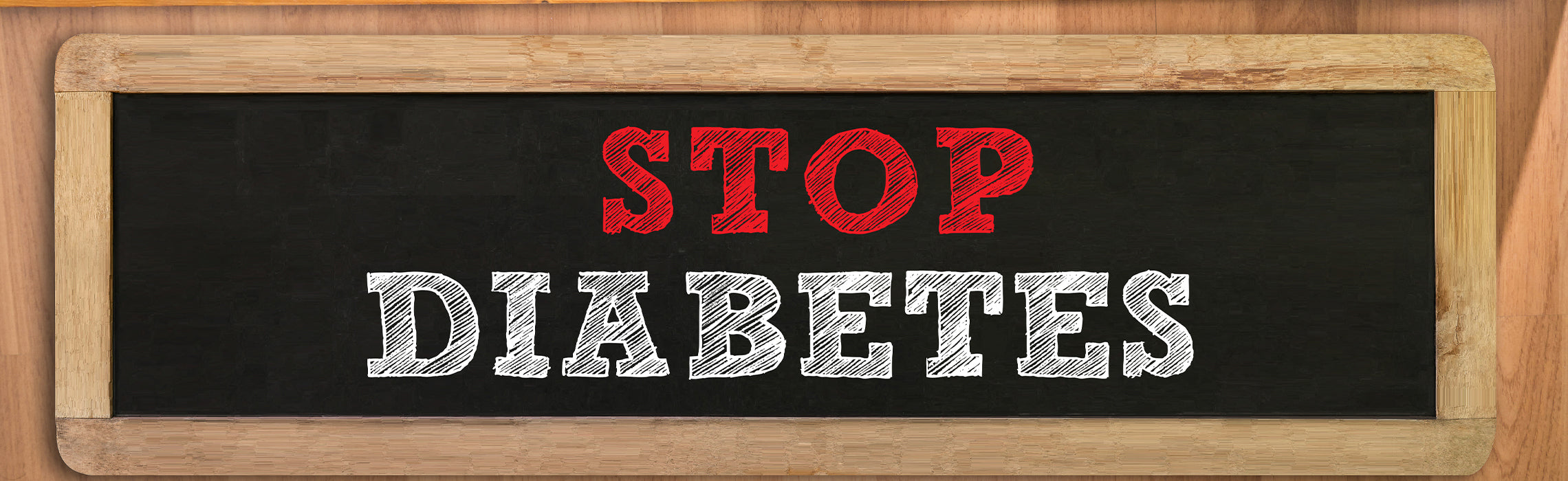 Chalkboard sign with bold text reading “STOP DIABETES” in red and white lettering against a black background with wooden frame.