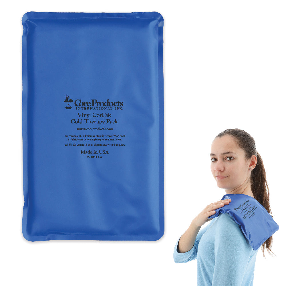 Core Products® Vinyl CorPak® Cold Therapy Pack in blue, shown in a large rectangular size with printed text: “Core Products International, Inc Vinyl CorPak Cold Therapy Pack… Made in USA.” A woman demonstrates use by placing the flexible pack on her shoulder for targeted cold therapy to help reduce pain, swelling, and inflammation.